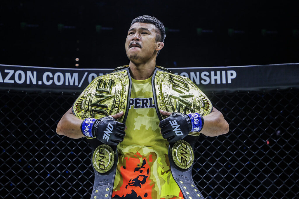 Superlek in posa con le cinture di ONE Championship - Kombatnet